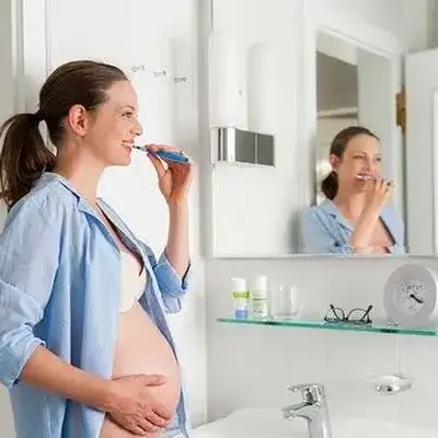 زن باردار در حال جرم‌گیری دندان در مطب دندانپزشکی